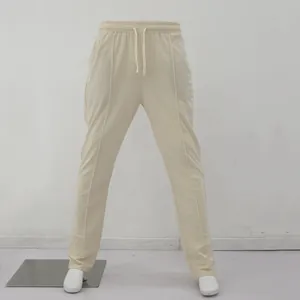 Vista frontal de pantalones deportivos beige con cordón y detalles de costuras