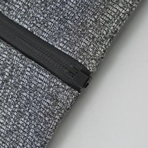 Close-up of black waterproof zipper on gray cationic fleece hoodie fabric detail