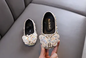 Nahaufnahme der funkelnden Schmetterlings-Strass-Dekoration auf Mädchen-Schuhen