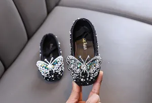 Nahaufnahme von Mädchen Prinzessinnenschuhen mit funkelndem Strass Schmetterling.