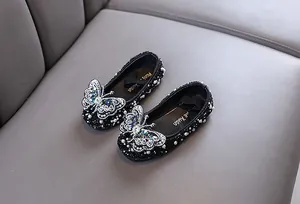 Detailansicht der schwarzen Mädchen-Prinzessin-Flachschuhe mit großem Strass-Schmetterling