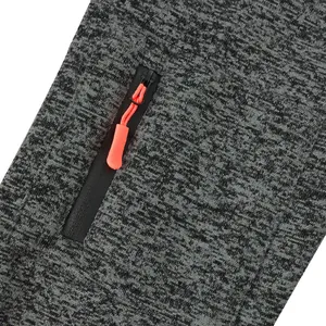 Detail view of a black zipper with an orange pull on grey cationic fleece fabric