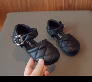 Primo piano di scarpe Mary Jane trapuntate nere da bambina con fibbia argento