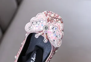 Detaillierte Nahaufnahme von rosa Mädchen-Prinzessinnenschuhen mit 3D-Schmetterling und Strass