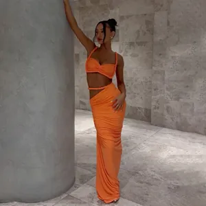 Detailansicht eines orangefarbenen rückenfreien Crop-Tops und Maxirocks am Model