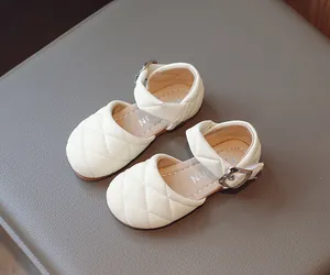 Vista dettagliata delle scarpe Mary Jane trapuntate crema per bambine con fibbia argento