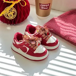 Sneakers invernali rosse festive per bambini con calda fodera in pile e decorazioni.