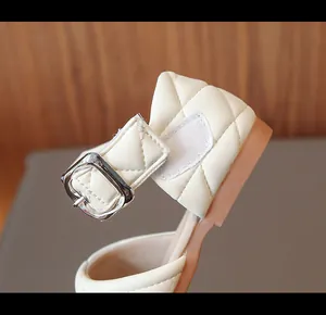 Primo piano di scarpa trapuntata da bambina con fibbia argentata e cinturino velcro.