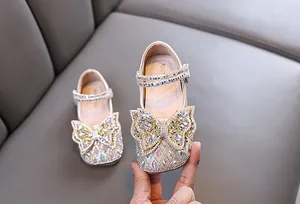 Vista detallada de la mariposa de diamantes de imitación brillantes en zapatos de princesa