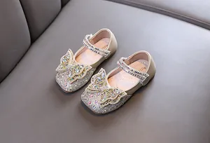 Vista detallada de manoletinas de princesa doradas para niña con mariposa y pedrería