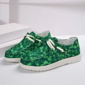 Green canvas loafers with all-over shamrock pattern and white laces for women