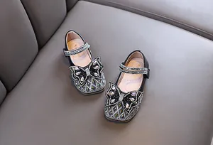 Primer plano de zapatos de princesa negros para niña con lazo de strass brillante