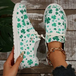 Casual white women's canvas loafers with vibrant green four-leaf clover print patterns