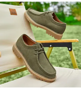 Detailed view of men's olive green suede wallabee derby shoes on an outdoor chair