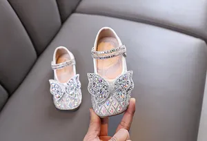Vista detallada de zapatos de princesa blancos para niñas con lazo de diamantes.