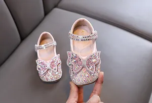 Primer plano de zapatos de princesa rosa para niñas con mariposa de diamantes de imitación