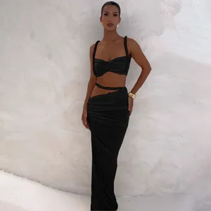 Sexyes schwarzes zweiteiliges Set mit rückenfreiem Crop Top und Wickelrock für Damen.