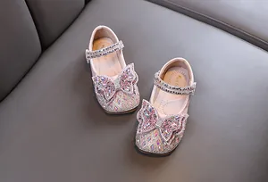 Primer plano de zapatos de princesa rosas para niñas con lazos de diamantes de imitación