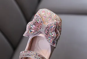 Primer plano de zapatos de princesa rosas para niñas con un lazo de diamantes de imitación