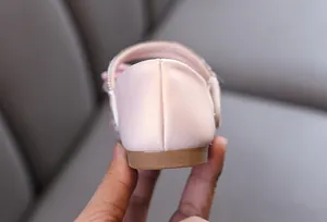 Detalle del talón de los zapatos de princesa rosa para niña con textura de cuero fino.