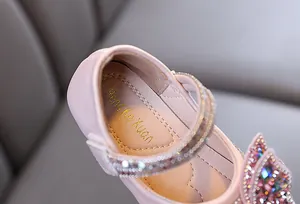 Detalle de zapato de princesa rosa para niñas con pedrería brillante y logotipo
