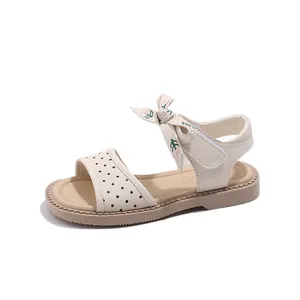 Sandalias de princesa para niña en crema con lunares negros y lazo.