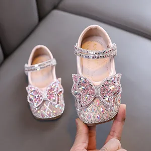Zapatos de princesa rosas para niñas con un gran lazo de diamantes para fiestas.