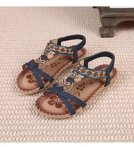 Detail view of navy blue bohemian sandals with beaded butterfly and floral patterns