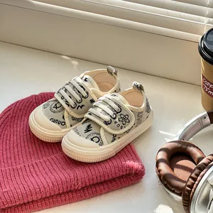 Nahaufnahme beige Leinenschuhe für Kleinkinder mit schwarzen Mustern und weichen Sohlen