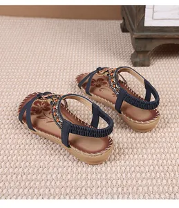 Detail of navy blue bohemian sandals with beaded flower straps and elastic heel