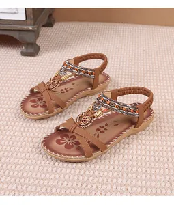 Detailed view of bohemian tan sandals with rhinestone flower and butterfly charms