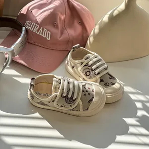 Detailaufnahme von cremefarbenen Kleinkind-Lauflernschuhen mit weichen Sohlen und Mustern