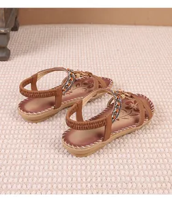 Close-up detail of brown Bohemian thong sandals featuring rhinestone flowers and elastic straps