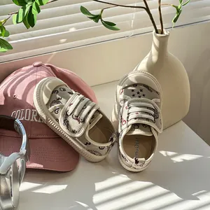Nahaufnahme von cremefarbenen Kinderschuhen mit Sternenmuster und Klettverschluss