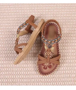 Detail view of brown bohemian thong sandals with rhinestones, beads and butterfly charms.