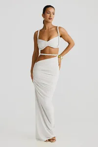 Ganzkörper-Detail von weißem zweiteiligem Crop-Top und gerafftem Maxirock-Set