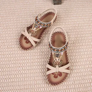 Detail view of Bohemian flat sandals with rhinestone butterflies and heart charms