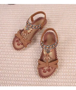 Close-up of Bohemian flat sandals with rhinestone butterfly charms and floral print