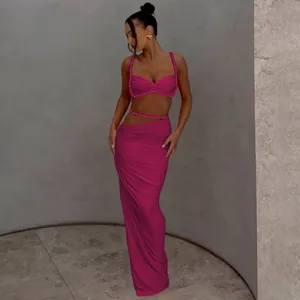 Ganzkörperansicht eines Models im sexy fuchsiafarbenen Zweiteiler mit Crop-Top und langem Rock