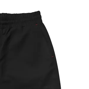 Close-up detail of men's black cargo pants featuring elastic waist and side pocket stitching
