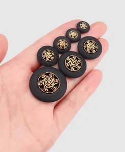 Set of matte black decorative buttons with intricate gold filigree centers