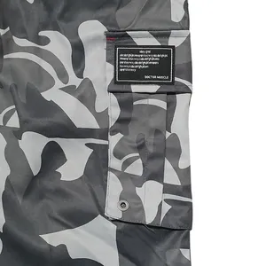Close-up detail of side cargo pocket featuring grey camouflage pattern and woven patch