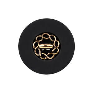 Eleganter runder Knopf in Schwarz und Gold mit filigranem Dekor für hochwertige Kleidung.