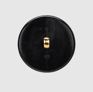 Close-up view of a high-end black nylon button with a golden shank back.