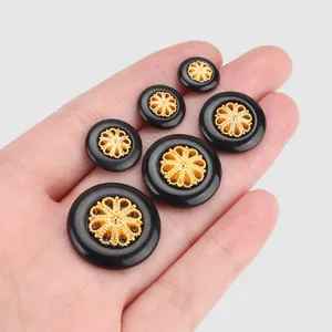 Elegante schwarze Nylonknöpfe mit goldenem filigranem Blumenzentrum, verschiedene Größen.