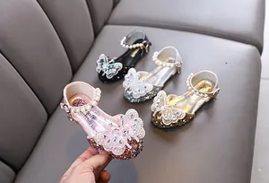 Detail showing sparkling girl's princess shoes with butterfly rhinestones and pearls