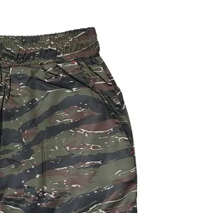Detail of tiger stripe camouflage cargo pants showing elastic waistband and side pocket