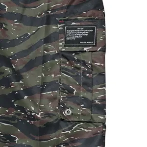 Macro view of tiger stripe camouflage cargo pants showing the side pocket and label