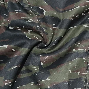 Detailed macro view showing the green and brown tigerstripe camouflage fabric texture of the cargo pants