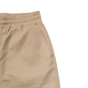 Detail of elastic waistband and side pocket with red stitching on men's cargo pants